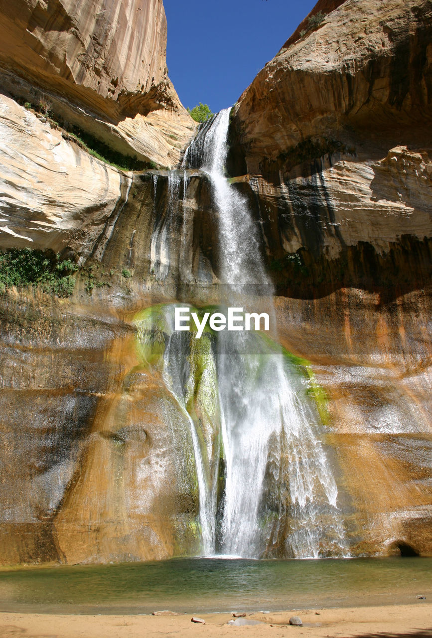 LOW ANGLE VIEW OF WATERFALL ALONG ROCKS