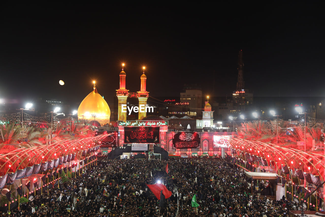 crowd, night, architecture, illuminated, group of people, event, celebration, built structure, building exterior, lighting equipment, large group of people, arts culture and entertainment, audience, outdoors, sports, red, concert, performance, city, sport venue