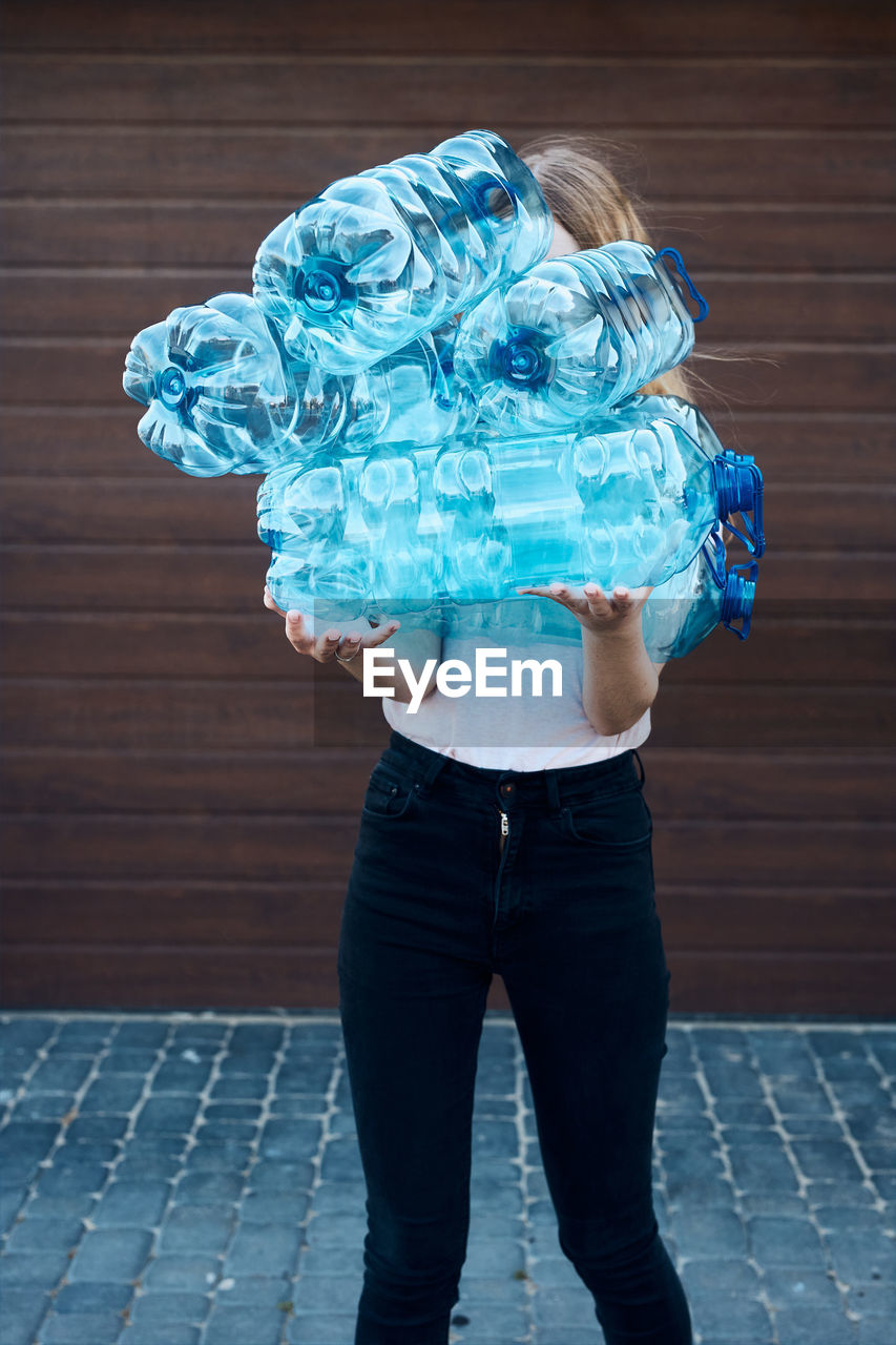 Midsection of woman standing against blue wall