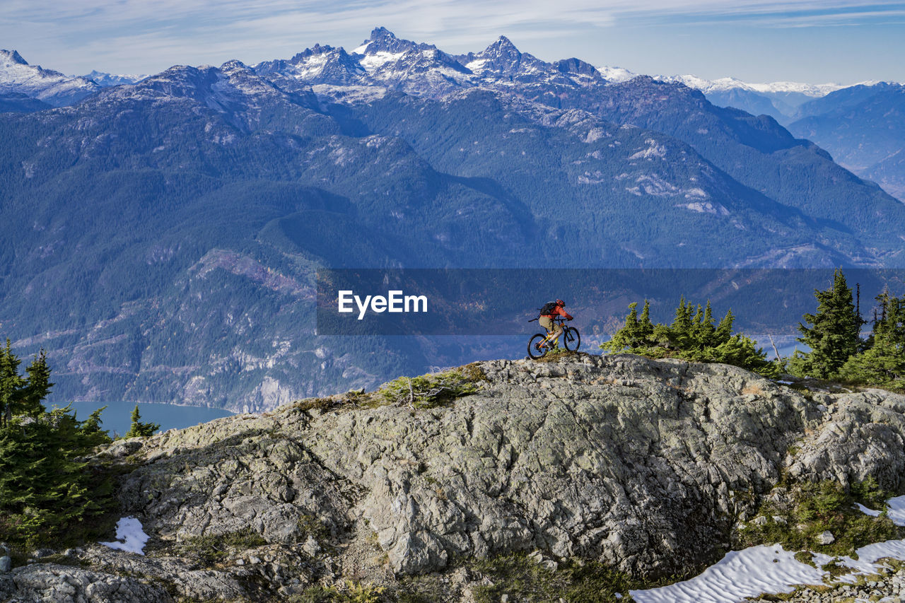 High angle view of man riding bicycle on mountain during winter