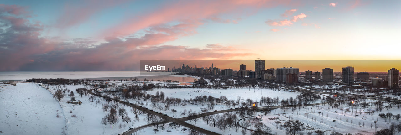 Beautiful chicago winter skyline aerial panorama above a snow covered landscape at sunset.