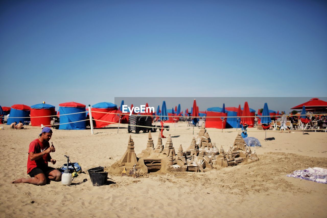 PANORAMIC VIEW OF PEOPLE RELAXING ON BEACH