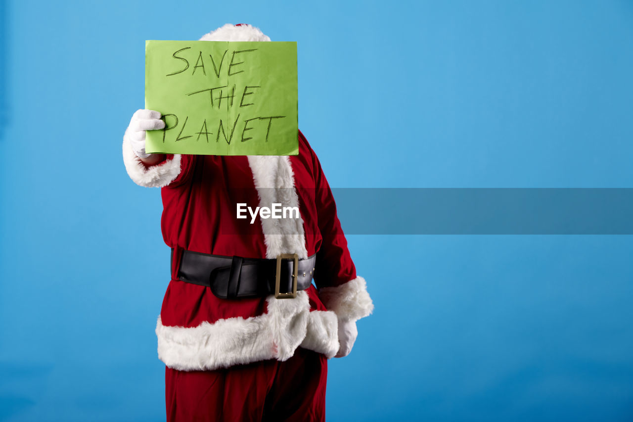 Santa claus with a save the planet poster on blue background