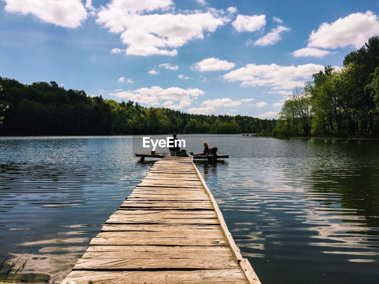 A family fishing on a pier in a lake