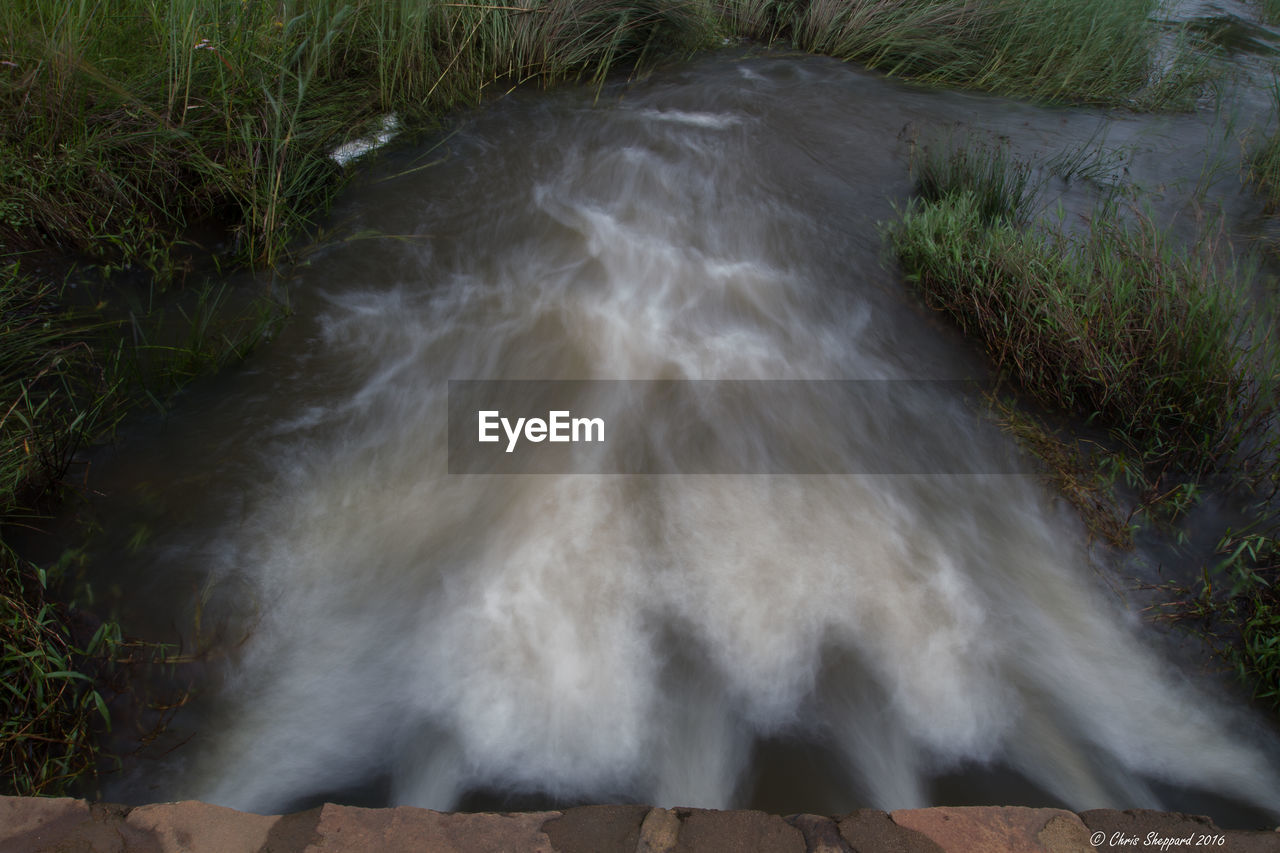 HIGH ANGLE VIEW OF WATER FLOWING FROM PIPE