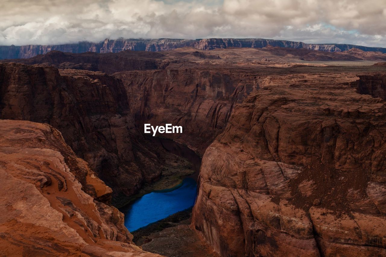 Scenic view of rock formations against cloudy sky