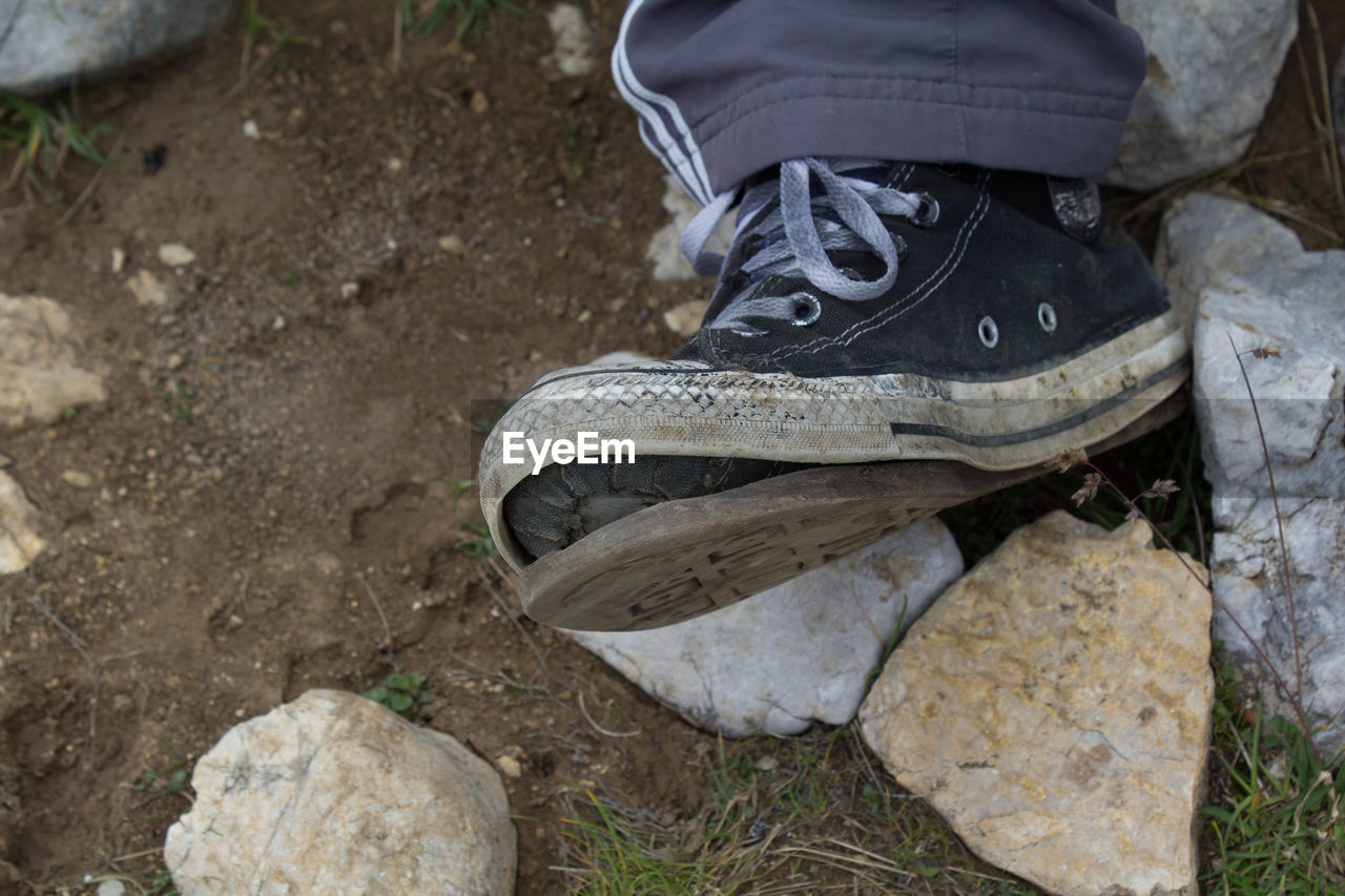 Low section of boy wearing shoes