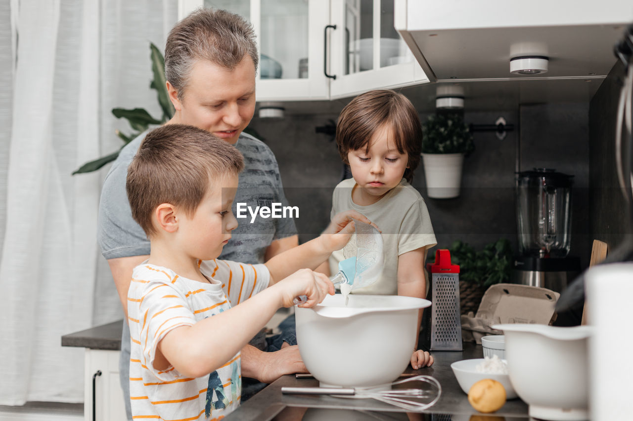 Father with sons in kitchen