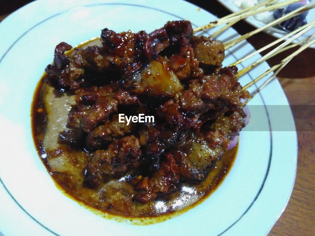 High angle view of roasted meat with skewers in plate