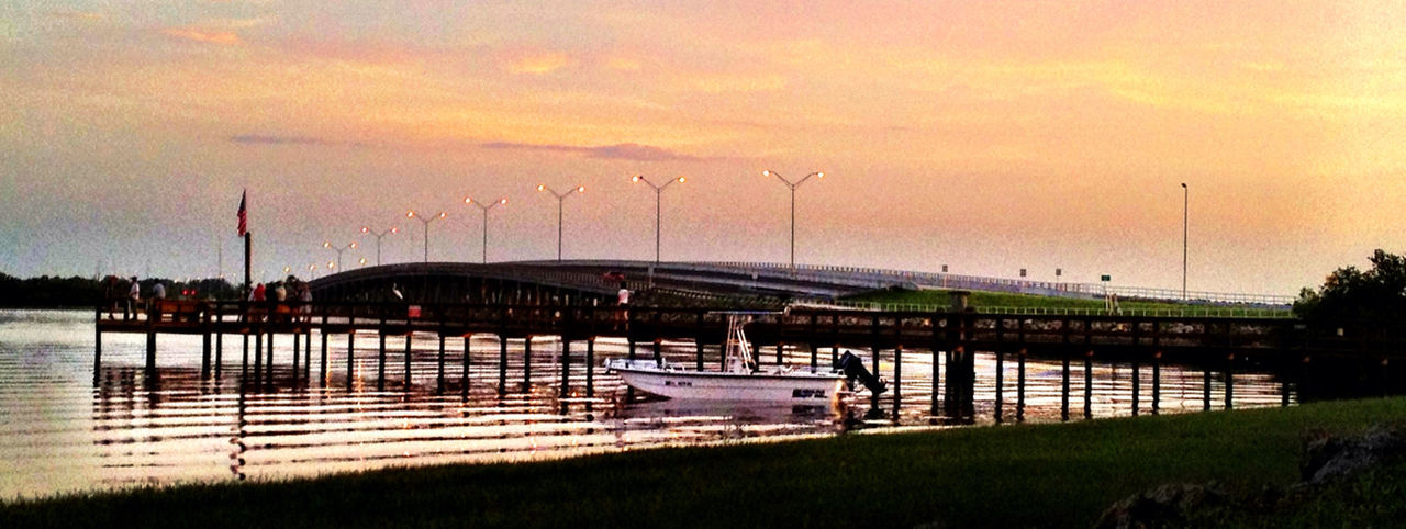 sky, sunset, water, nature, evening, dusk, cloud, architecture, transportation, pier, built structure, beauty in nature, no people, sea, outdoors, tranquility, scenics - nature, reflection, mode of transportation, tranquil scene, plant, dock, grass, orange color, environment