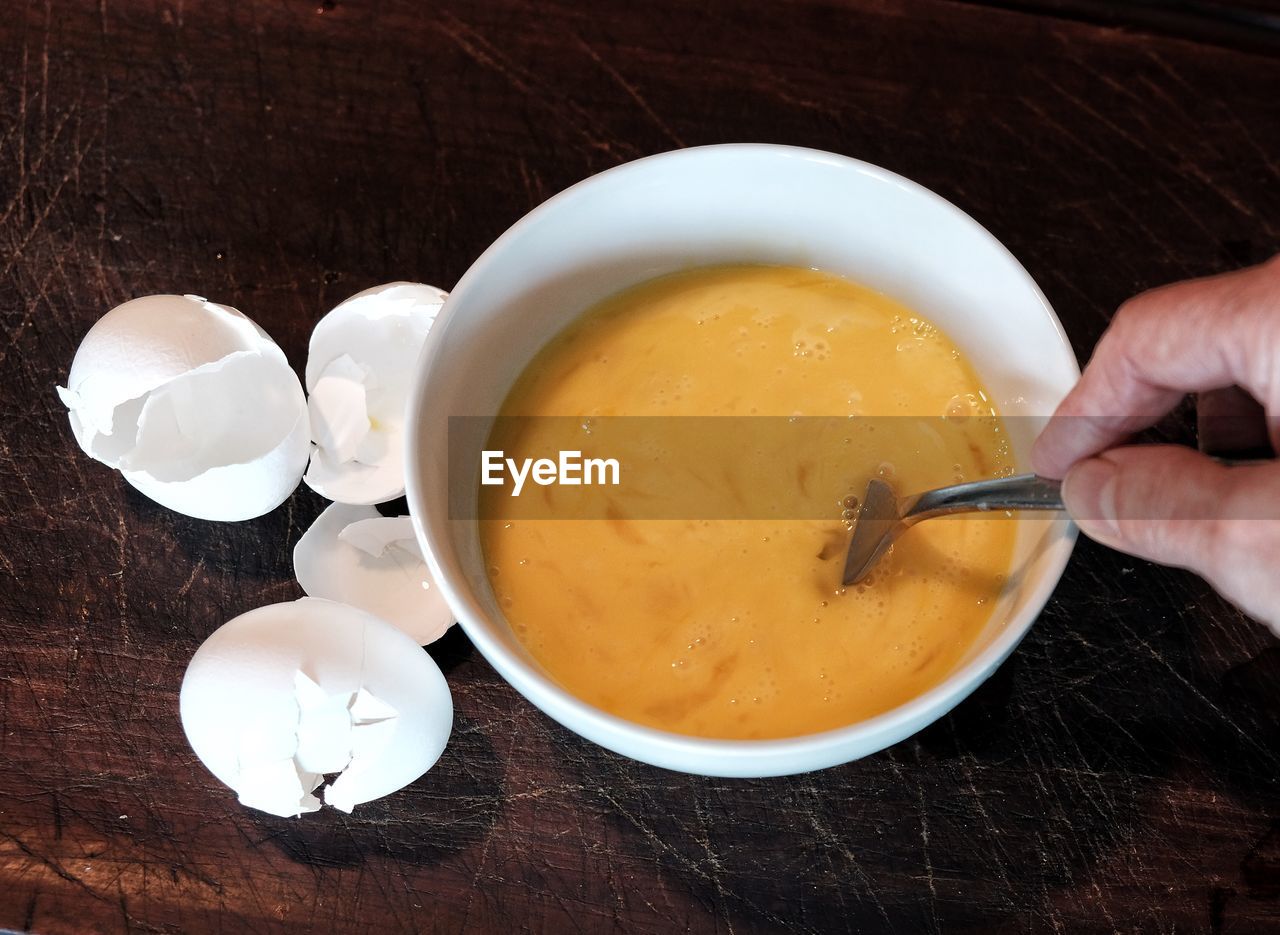 DIRECTLY ABOVE SHOT OF HAND HOLDING BOWL OF SOUP