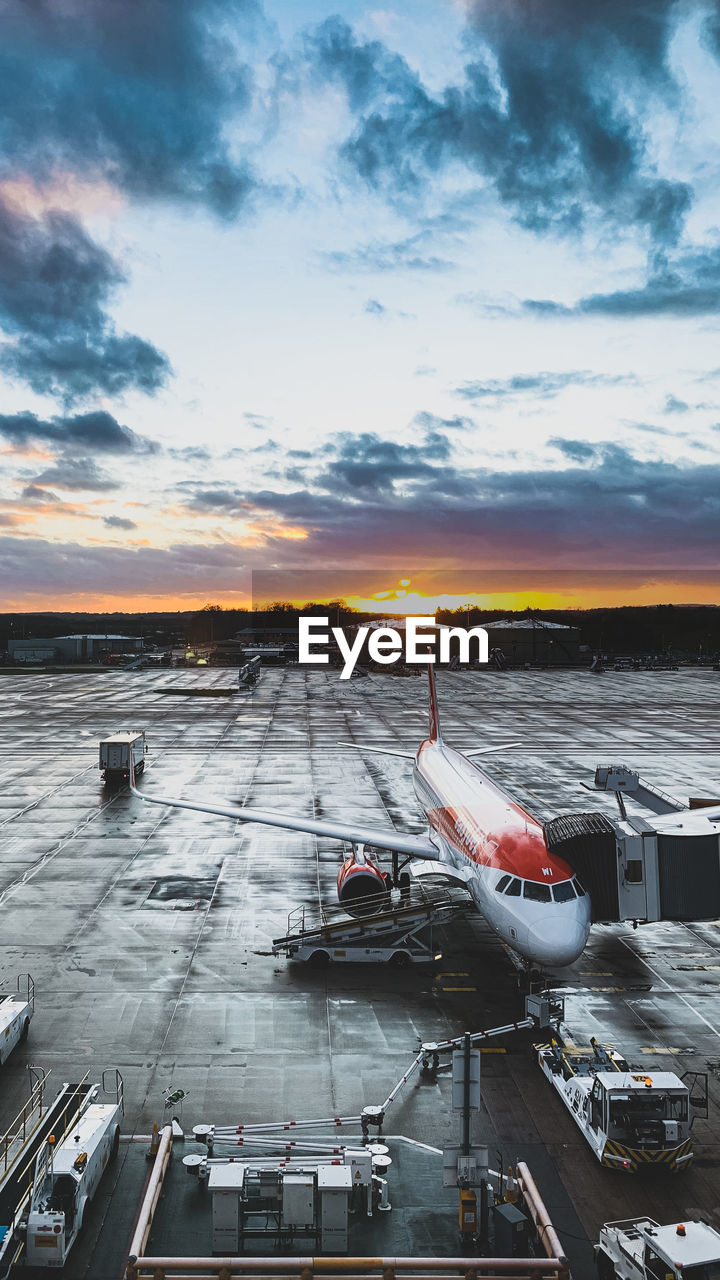 HIGH ANGLE VIEW OF AIRPLANE AT AIRPORT DURING SUNSET