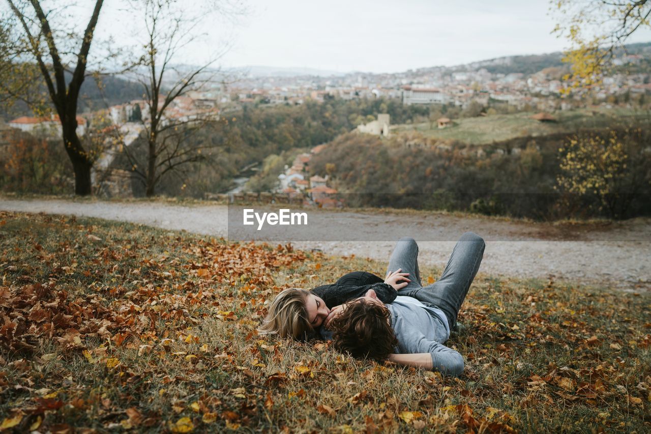 Couple lying on grass during autumn