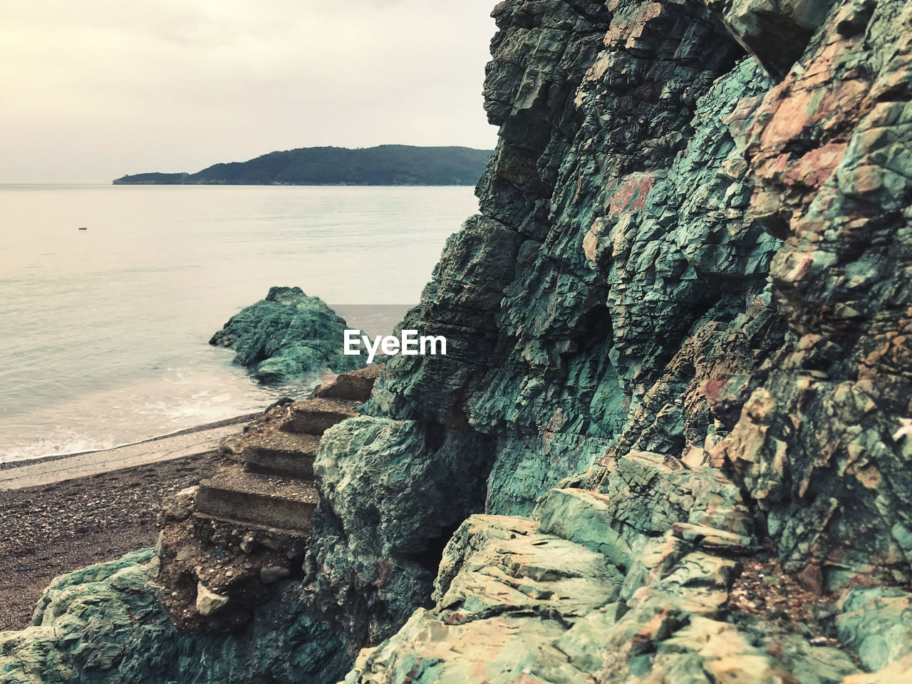 ROCK FORMATIONS ON SHORE AGAINST SKY