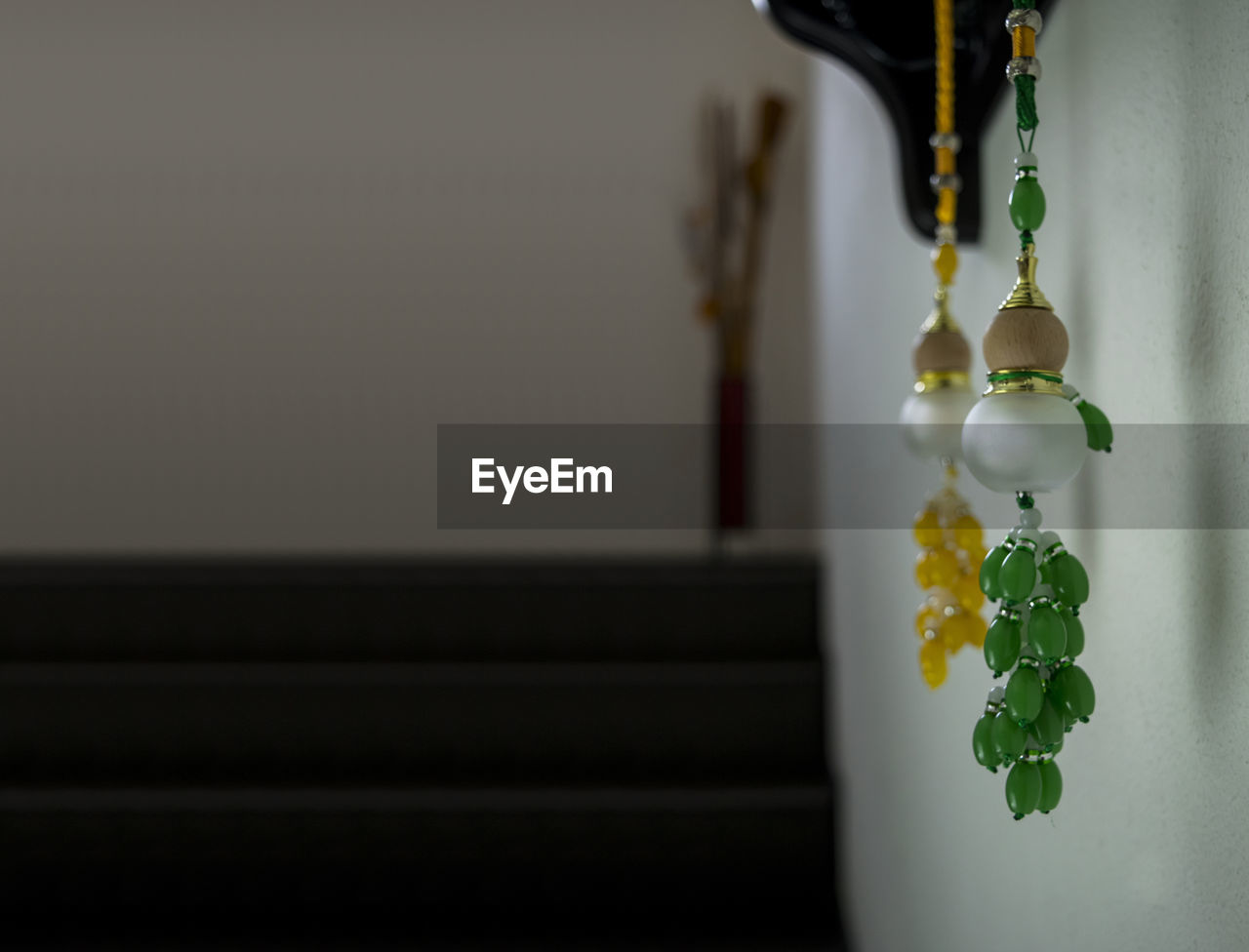 Close-up of green and yellow decorations hanging by wall