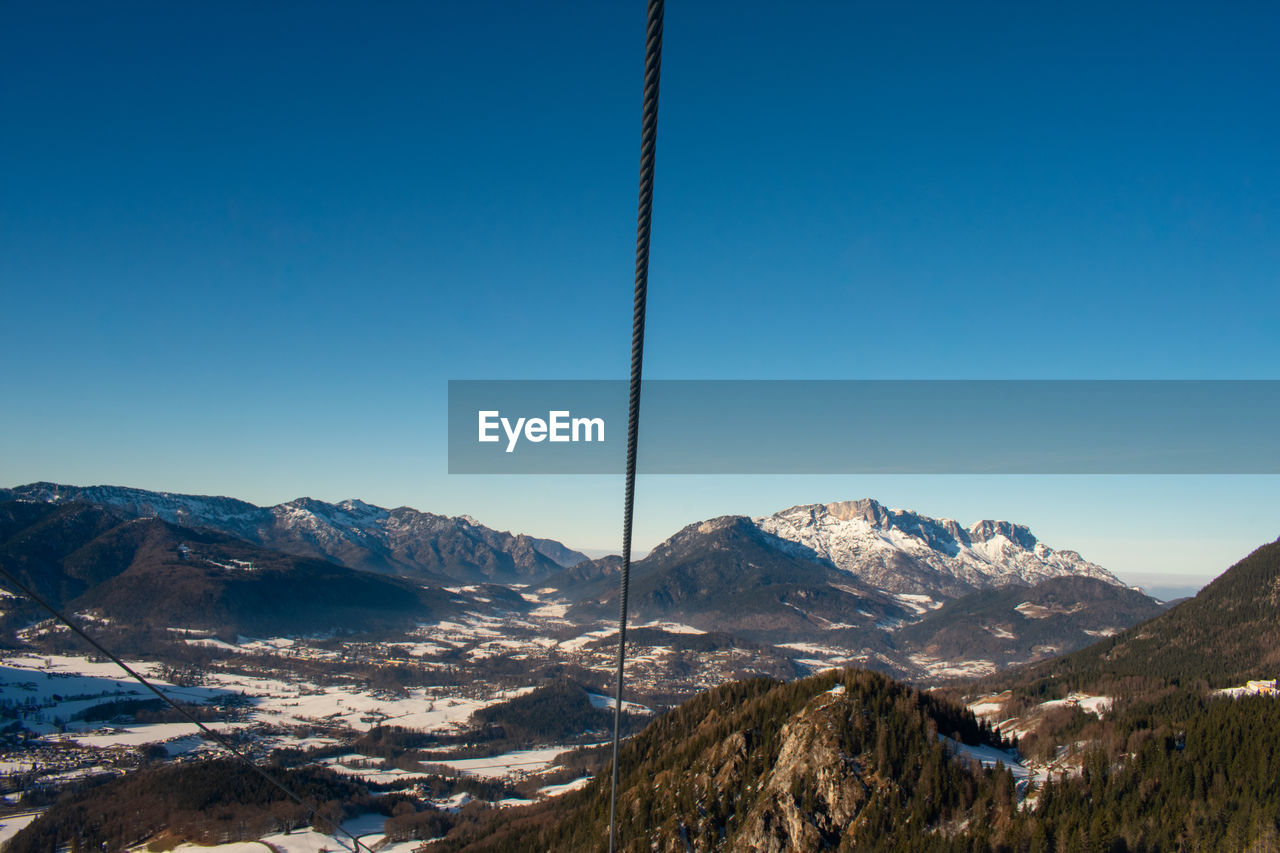 Scenic view of snowcapped mountains against clear blue sky