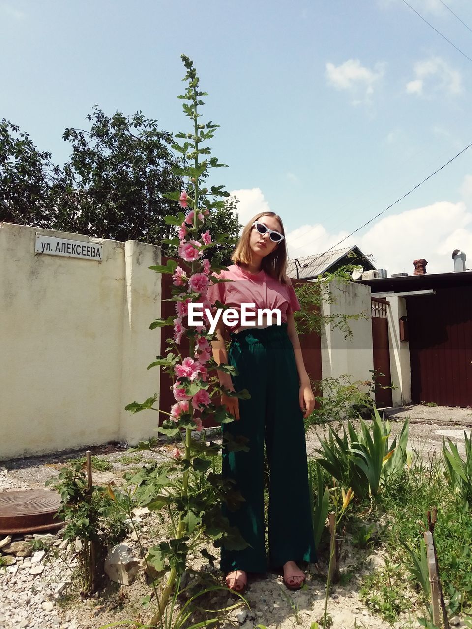 Portrait of woman by standing flowering plant