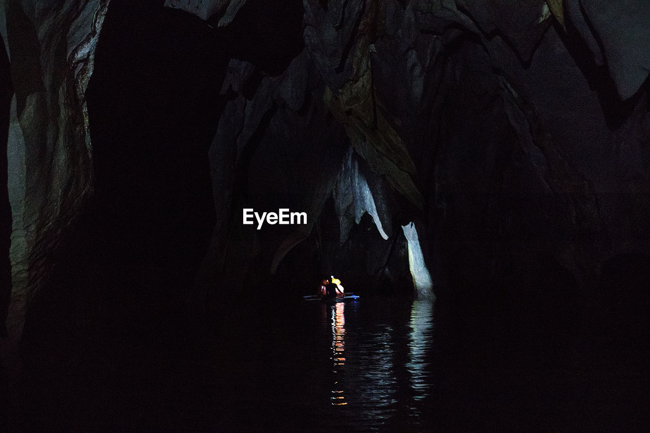 Man sailing boat in river amidst mountain