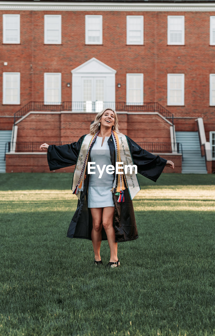 FULL LENGTH OF YOUNG WOMAN WALKING ON GRASS