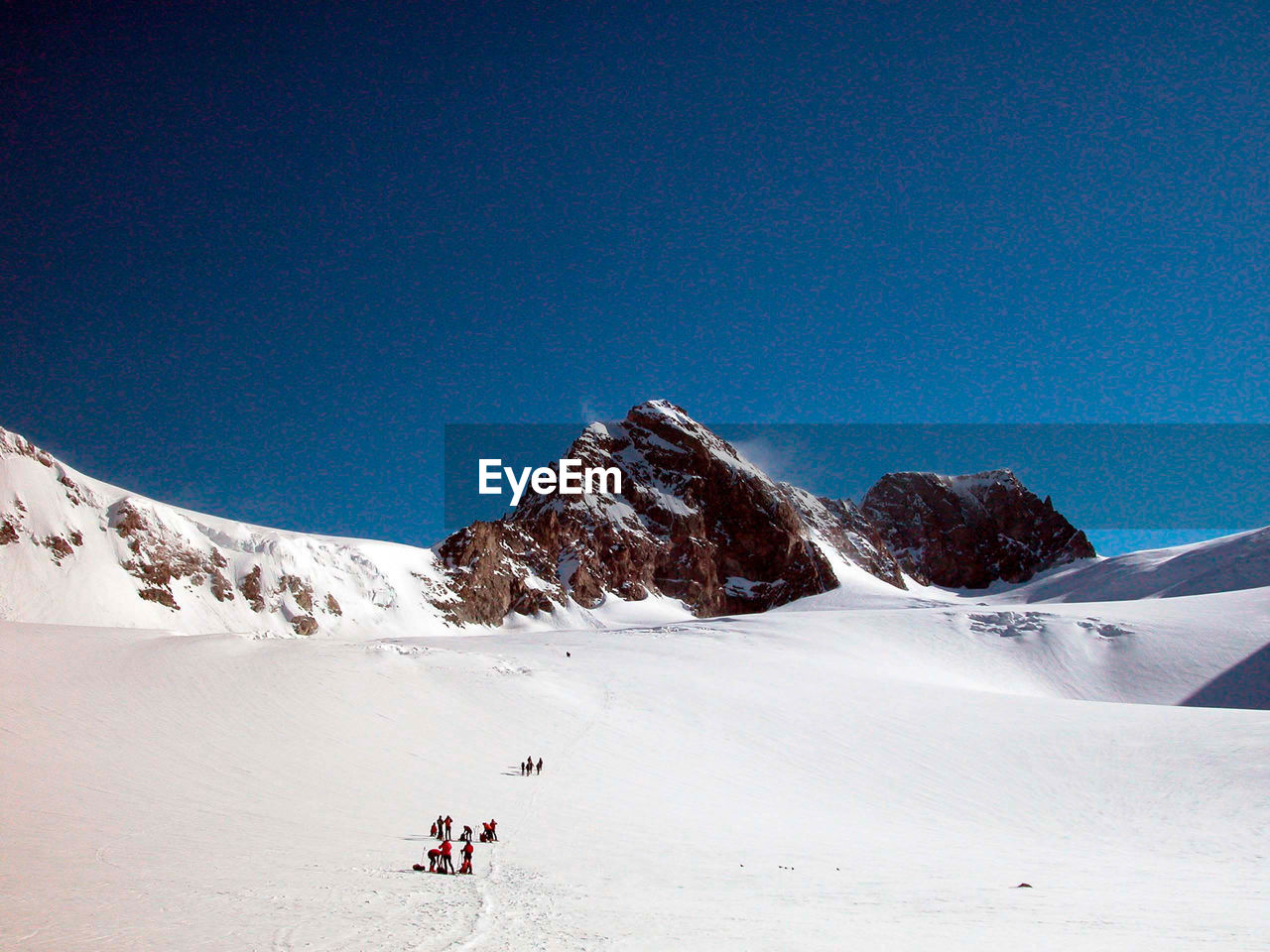 Ski tour group on a snowy mountain on a sunny winter day