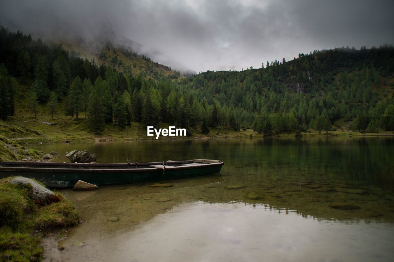 Scenic view of lake by trees against sky