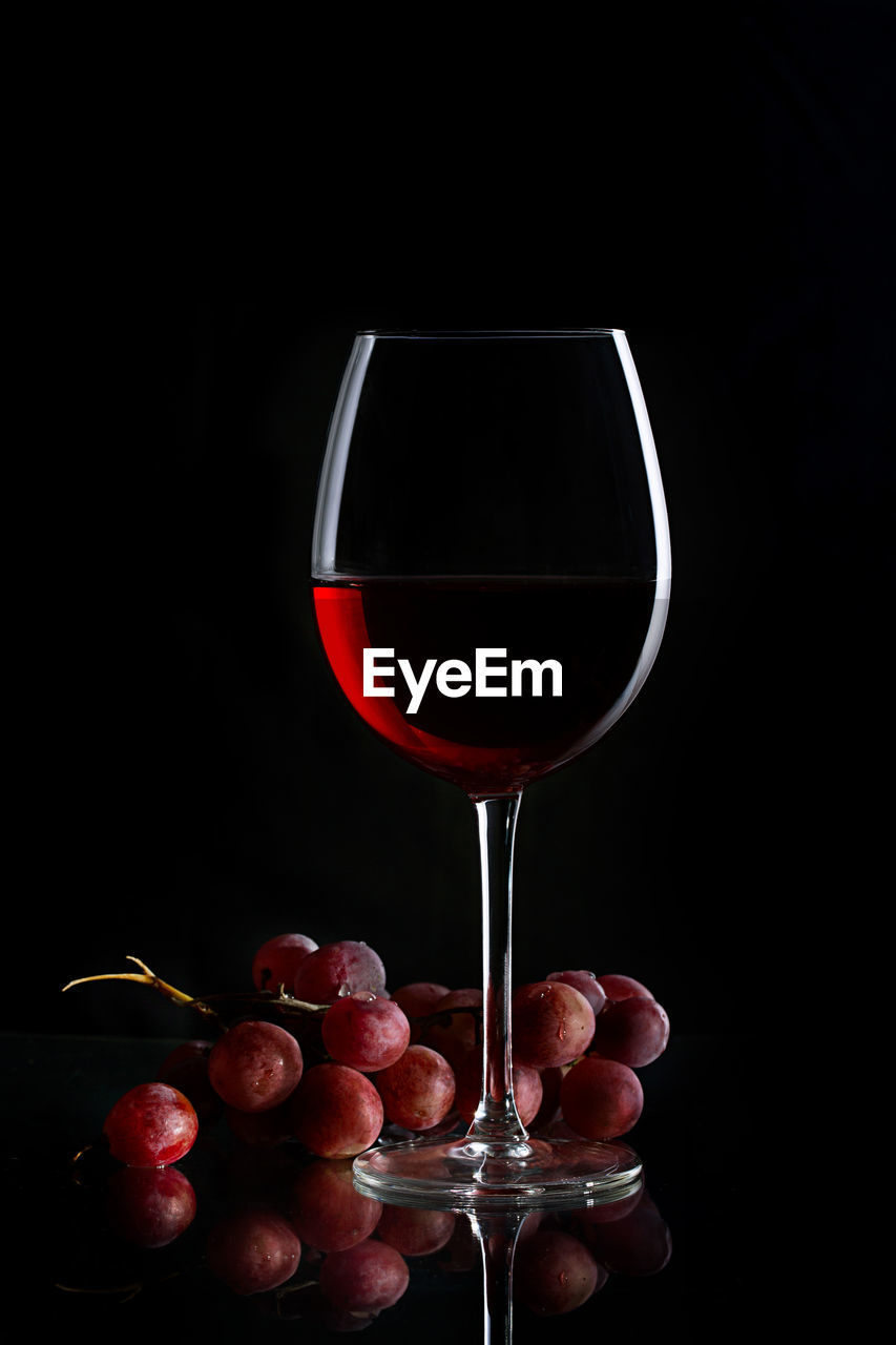 CLOSE-UP OF RED WINE AGAINST BLACK BACKGROUND