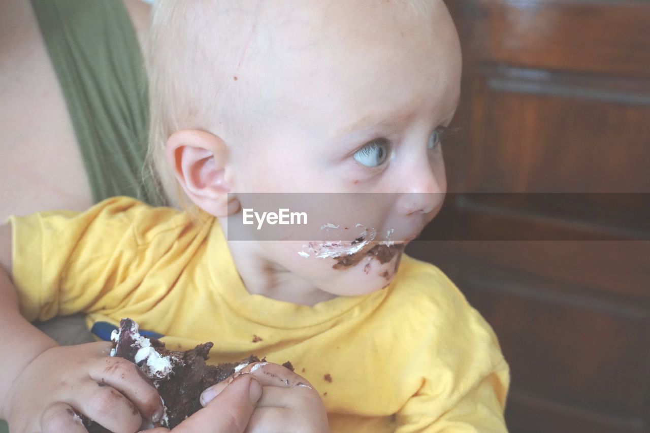 Close-up of cute baby boy eating cake