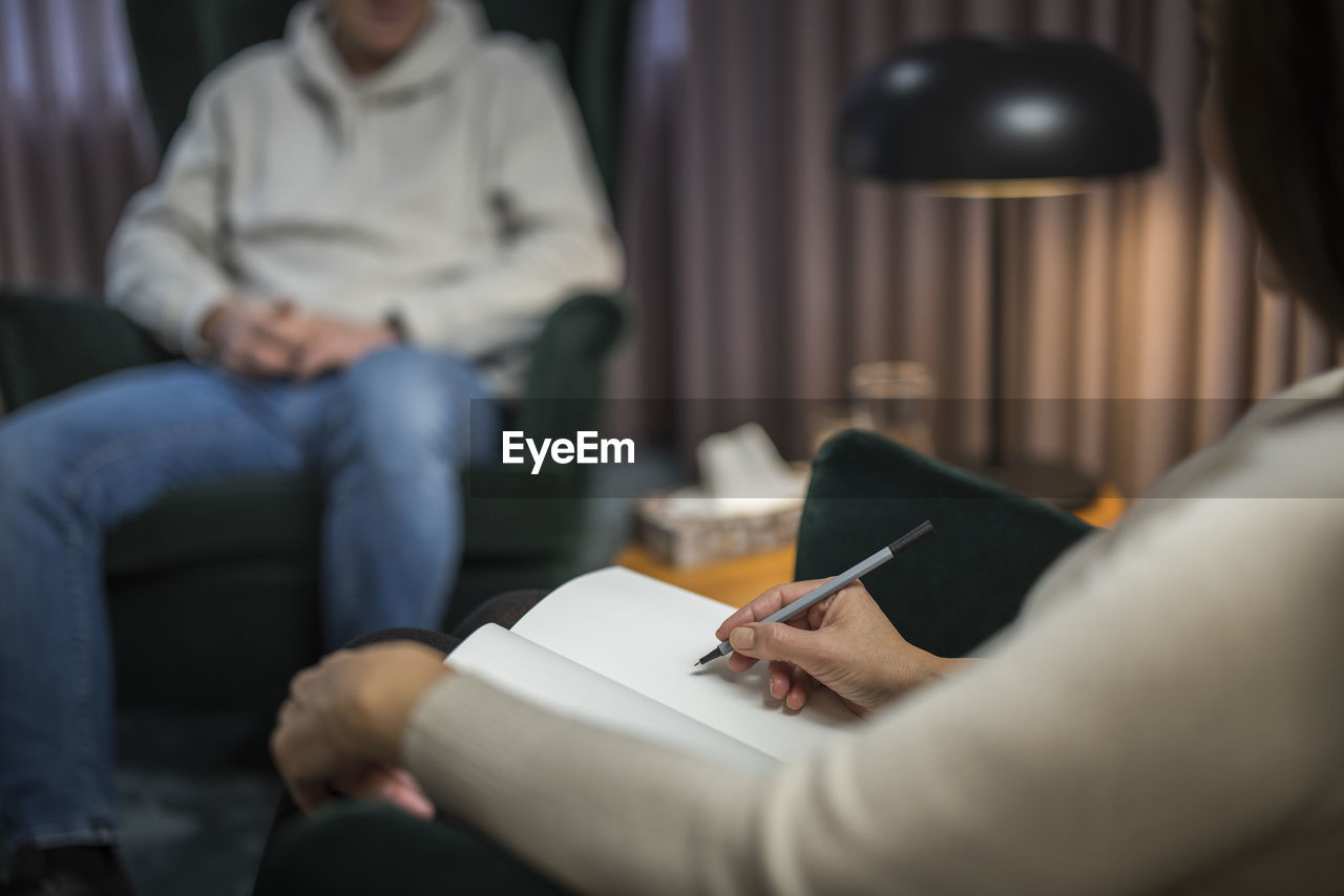 Female doctor taking notes at therapy session