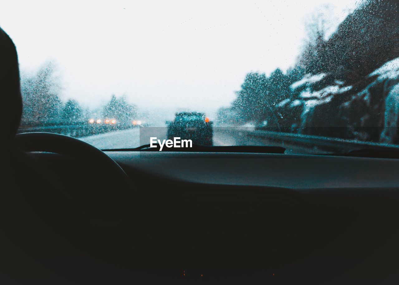 CLOSE-UP OF CAR AGAINST SKY SEEN THROUGH WINDSHIELD