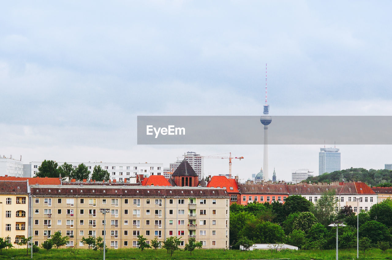 Mid distance view of fernsehturm against sky in city