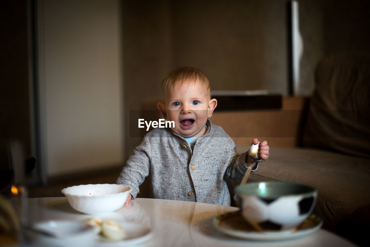 Portrait of cute boy having food at home