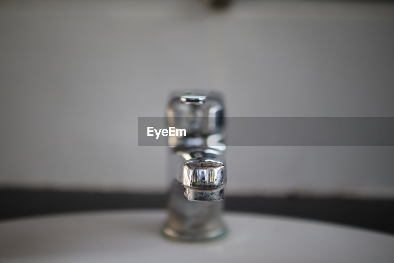 Close-up of water faucet on table