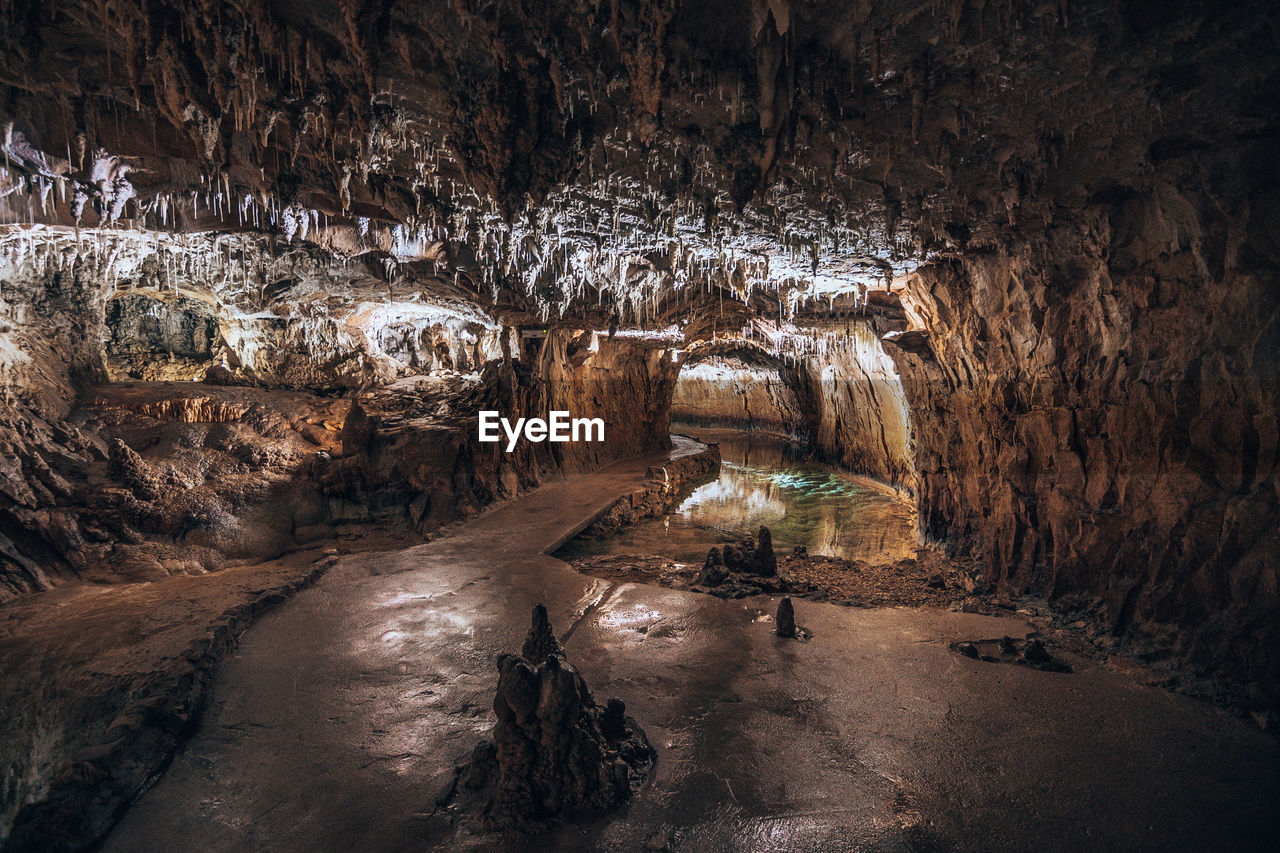 VIEW OF ILLUMINATED CAVE THROUGH WATER