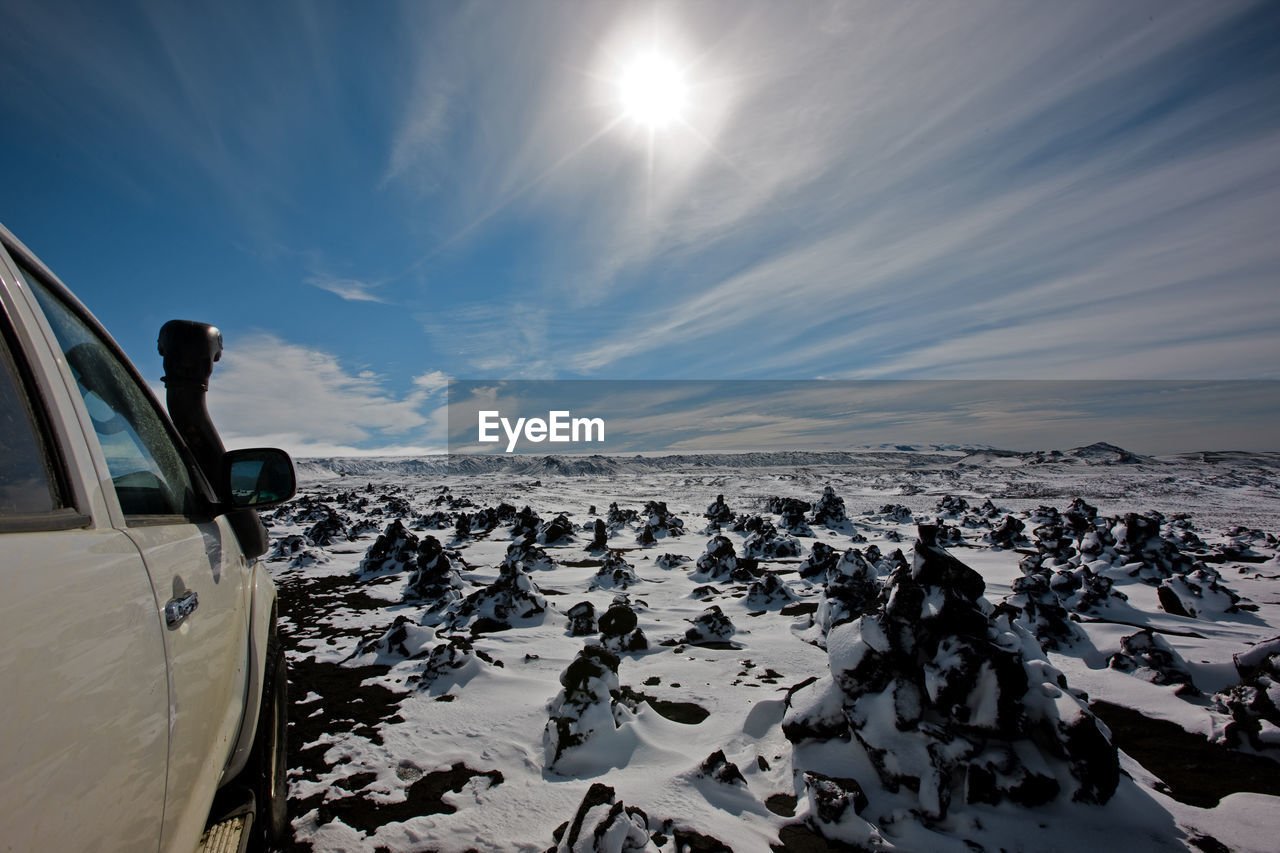 Suv driving through snowy landscape in the icelandic highlands