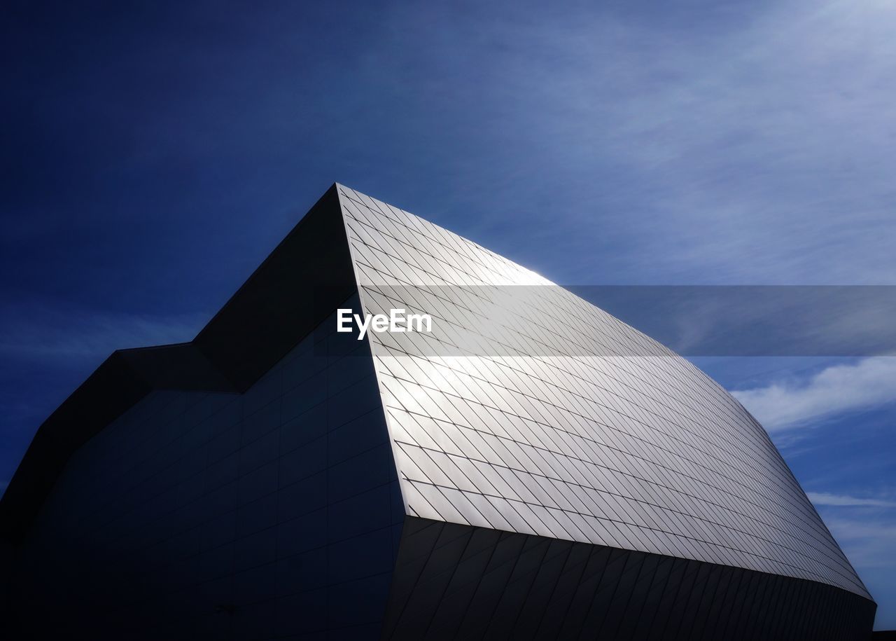 Low angle view of modern building against blue sky