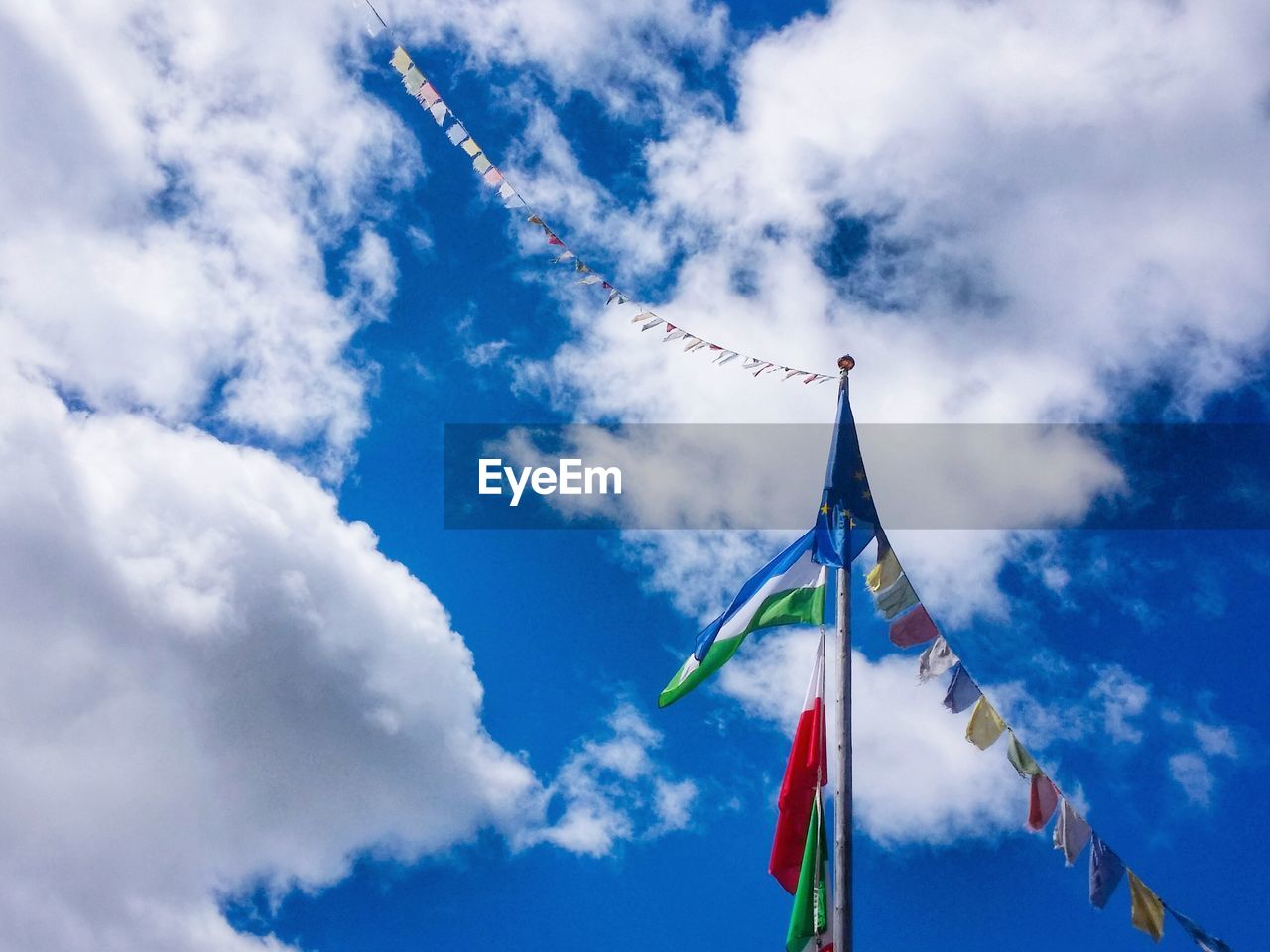 Low angle view of flags on pole against sky
