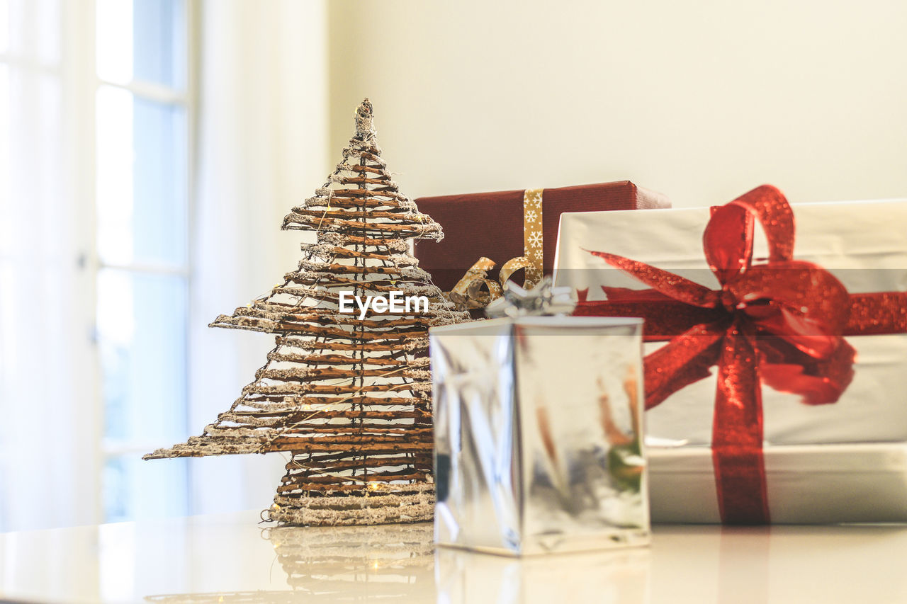 Gift boxes near christmas tree inside home. box with holiday ribbon with bows. festive atmosphere