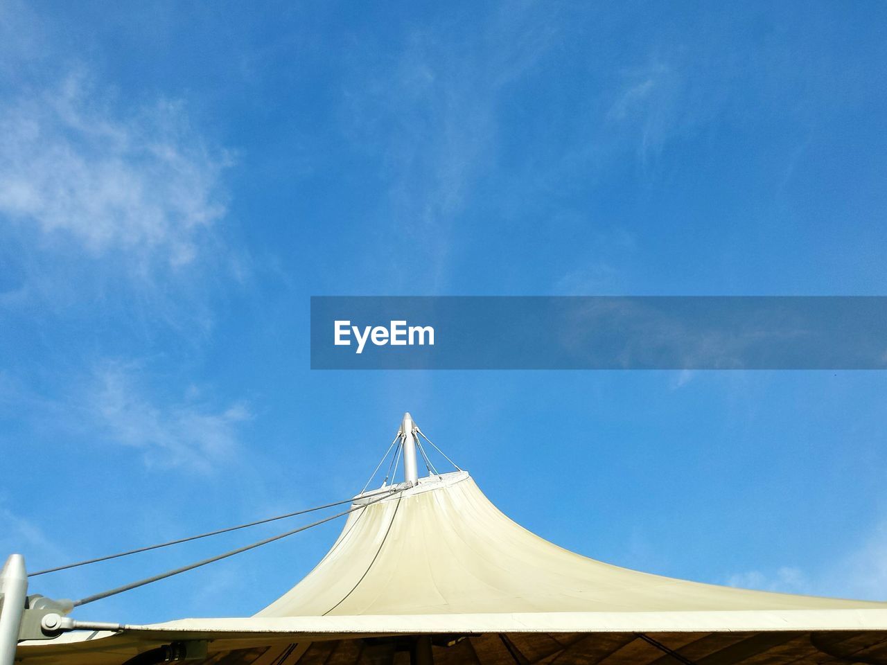 Low angle view of circus tent against blue sky during sunny day