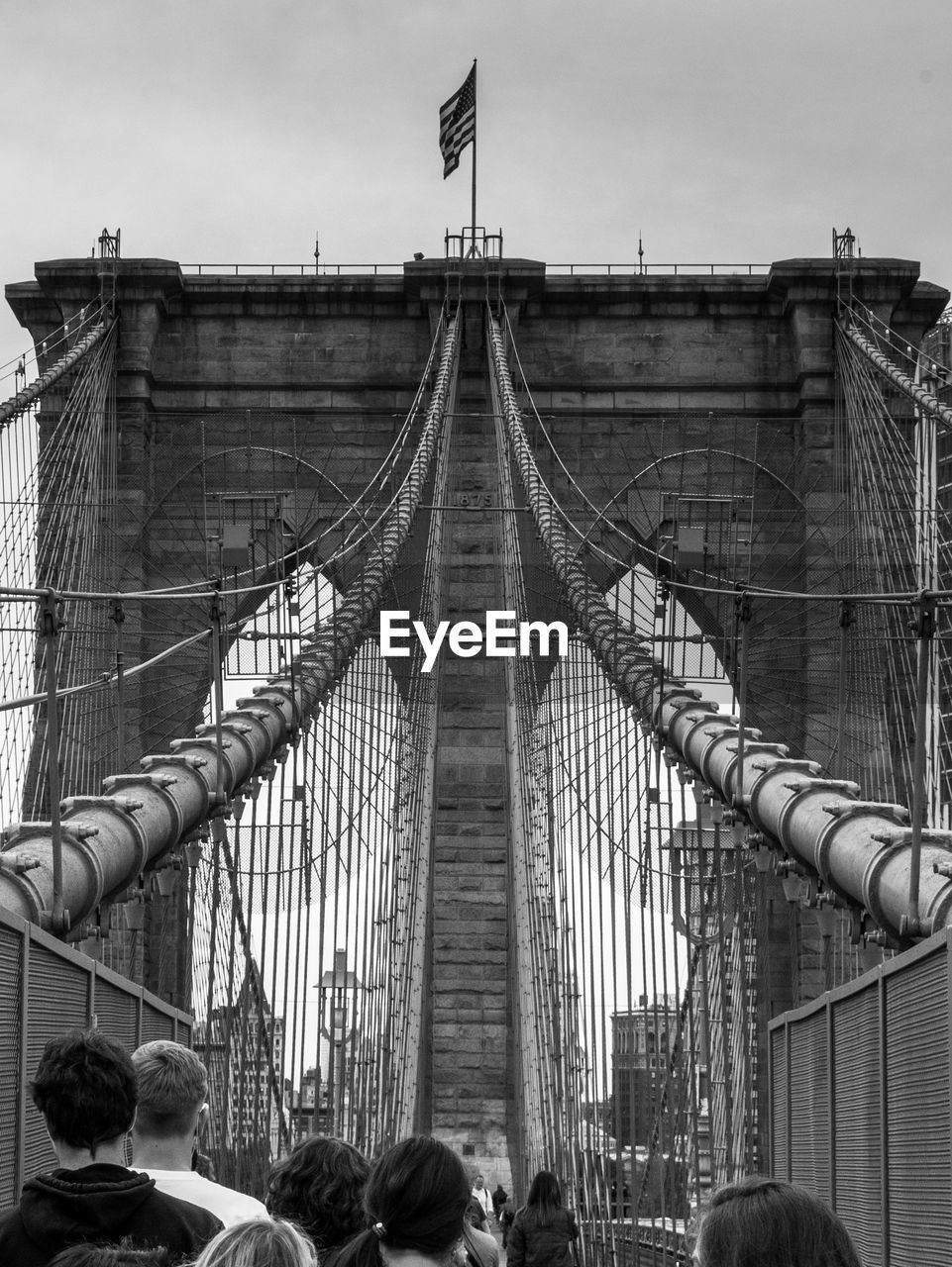 People on brooklyn bridge against sky