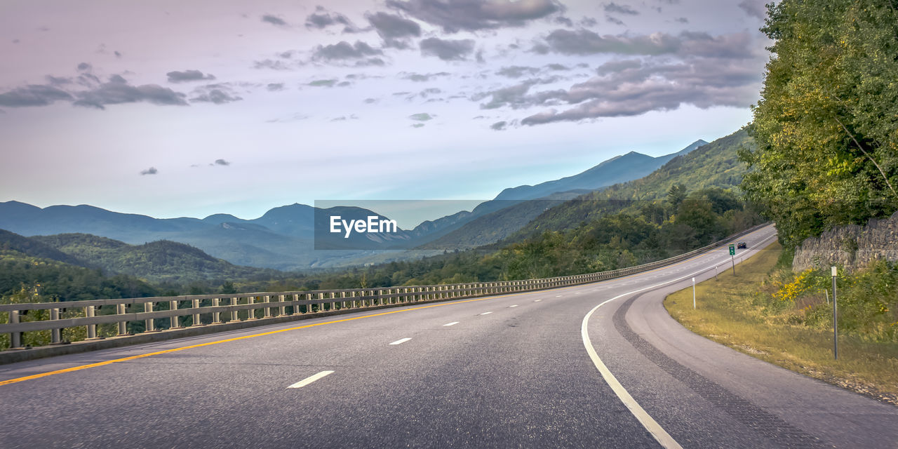 EMPTY ROAD AGAINST MOUNTAINS