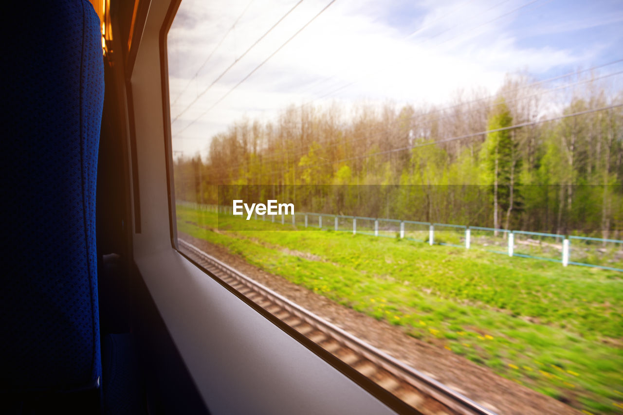 SCENIC VIEW OF TRAIN SEEN THROUGH WINDOW OF RAILROAD TRACK