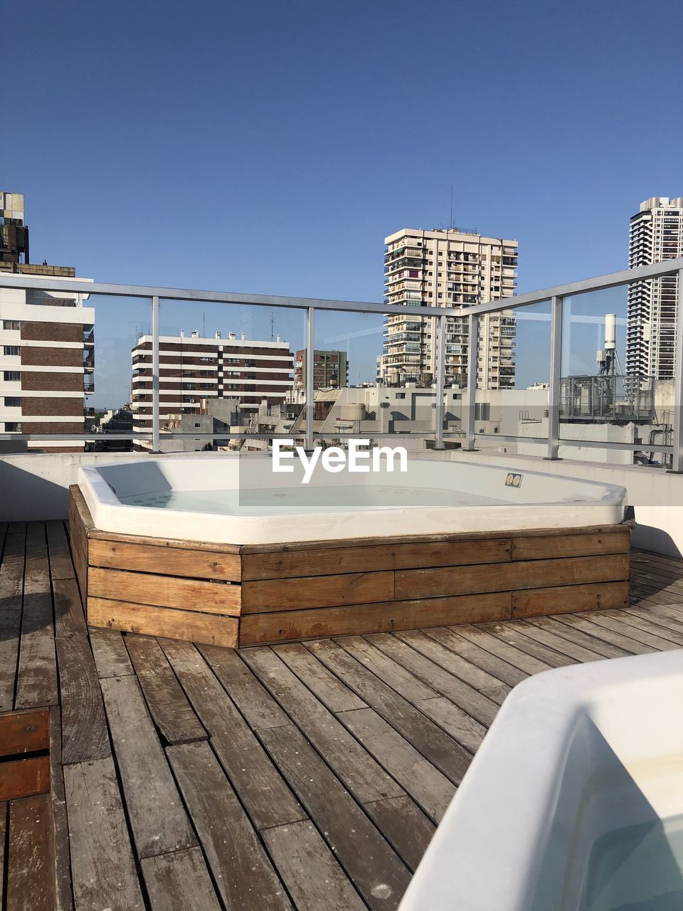 SWIMMING POOL BY BUILDINGS AGAINST CLEAR BLUE SKY