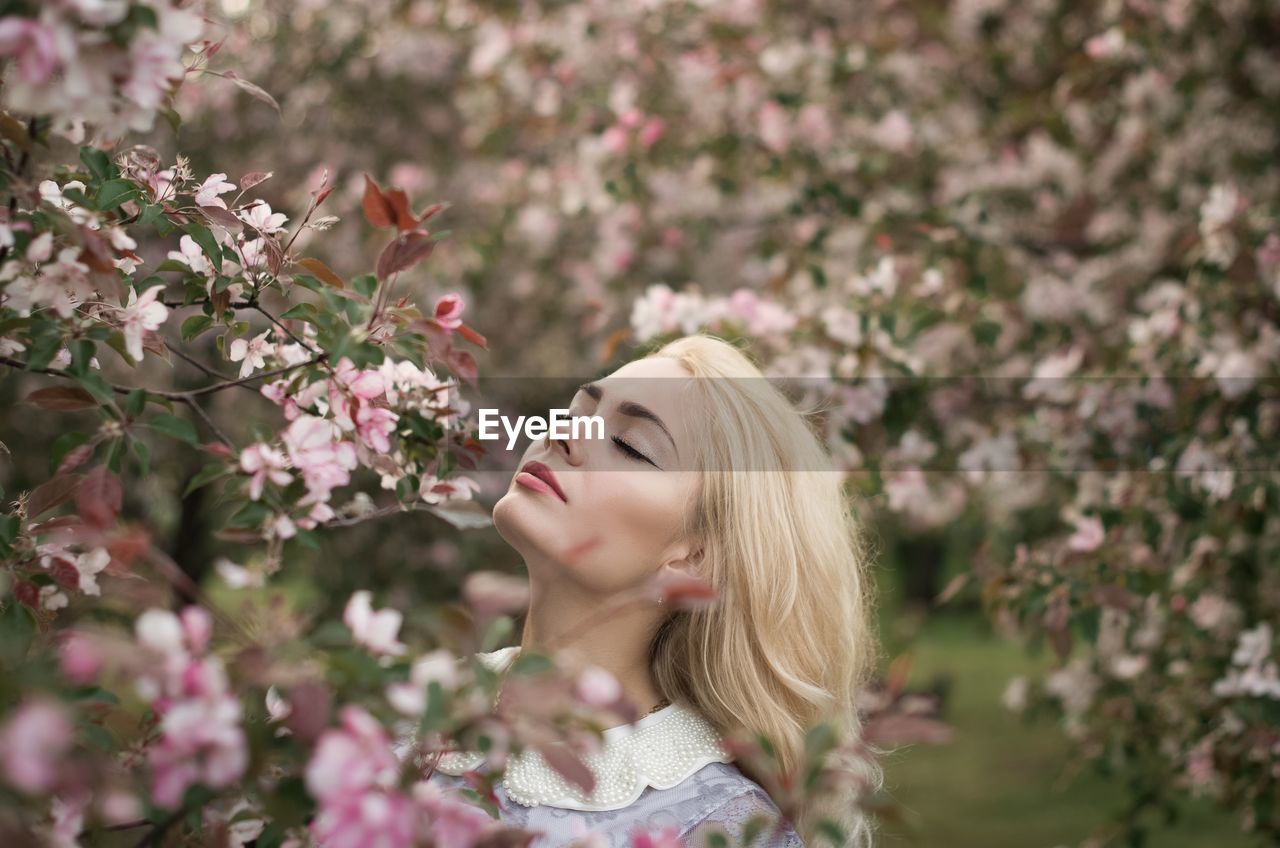 Young woman smelling flowers outdoors