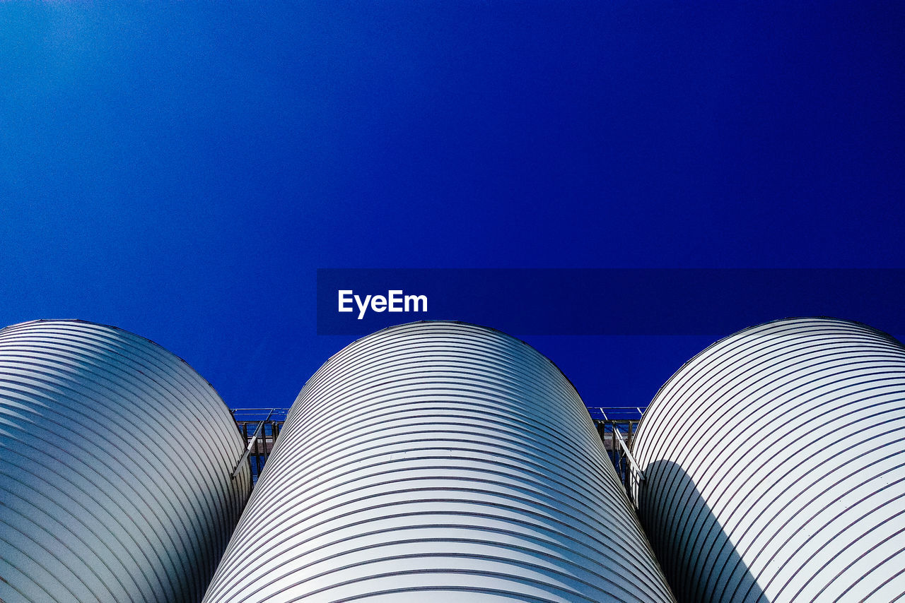 Low angle view of modern building against clear blue sky