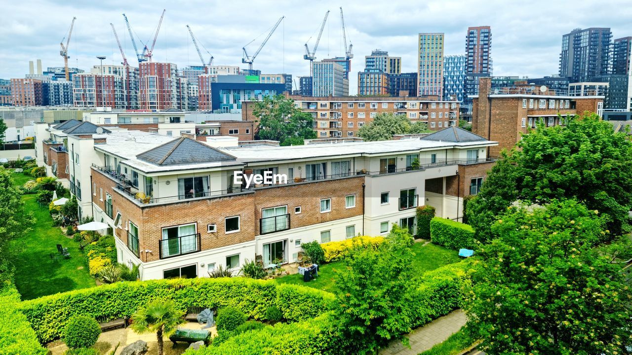 architecture, building exterior, built structure, city, building, neighbourhood, urban area, residential area, residential district, cityscape, sky, plant, nature, landmark, landscape, tree, town, downtown, office building exterior, urban skyline, metropolitan area, skyline, city life, suburb, cloud, estate, no people, skyscraper, outdoors, construction industry, day, tower block, house, industry, travel destinations, high angle view, environment, travel, office, downtown district, green, business, development