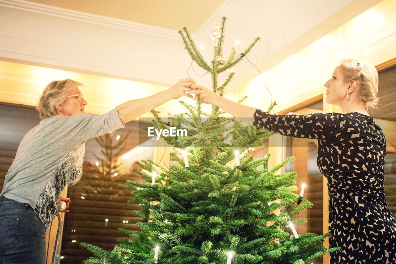Women decorating christmas tree