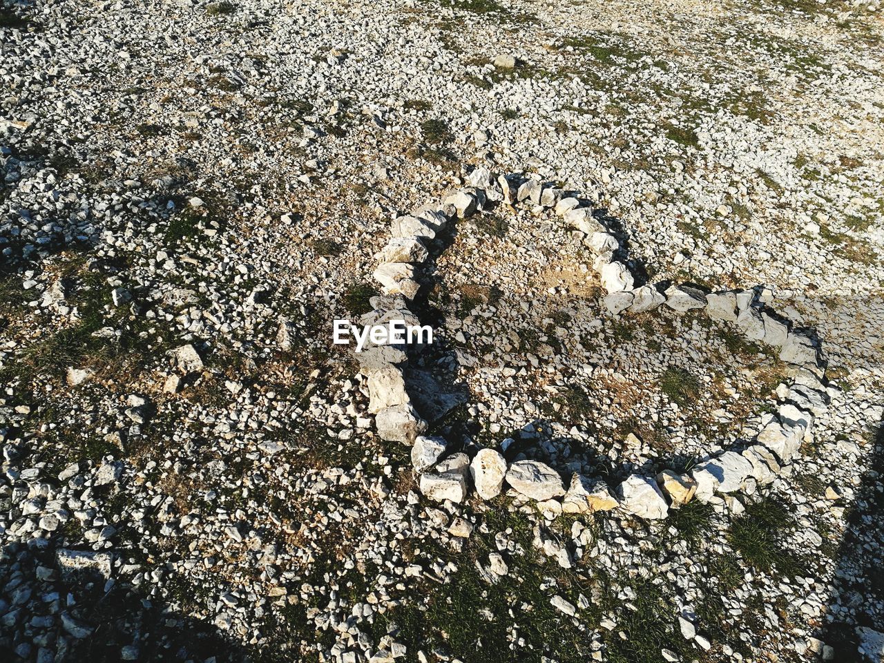 High angle view of heart shape made by stones at beach on sunny day