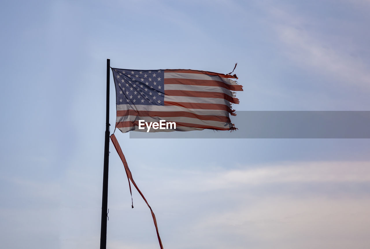 low angle view of flag against cloudy sky