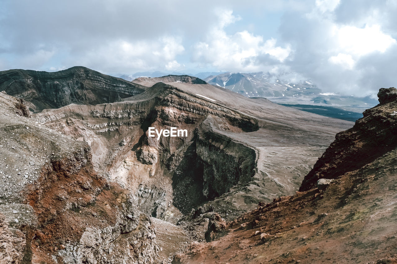 cloud, environment, mountain, landscape, sky, scenics - nature, beauty in nature, nature, wilderness, land, travel destinations, mountain range, travel, geology, adventure, rock, non-urban scene, ridge, walking, outdoors, no people, activity, mountain pass, tourism, tranquility, extreme terrain, overcast, tranquil scene, day, plateau, panoramic, cloudscape, terrain, social issues, leisure activity, cold temperature, dramatic sky, water, snow, outdoor pursuit, valley