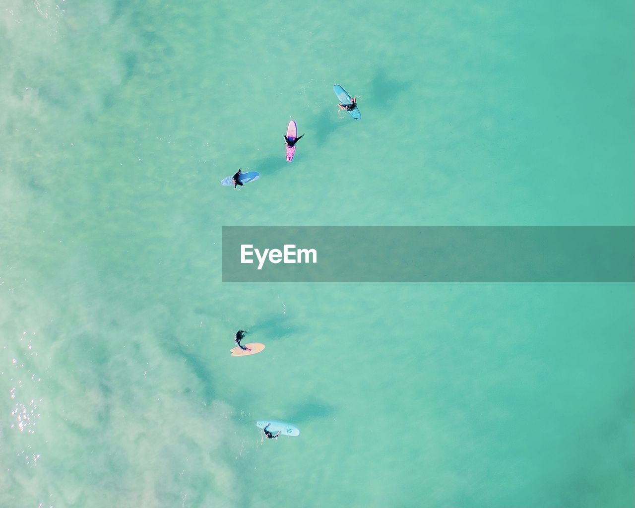 HIGH ANGLE VIEW OF PEOPLE FLYING IN SEA